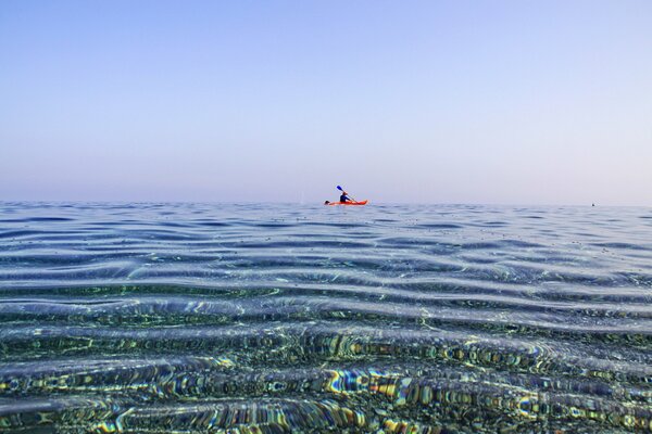 A man in a canoe swims in the sea