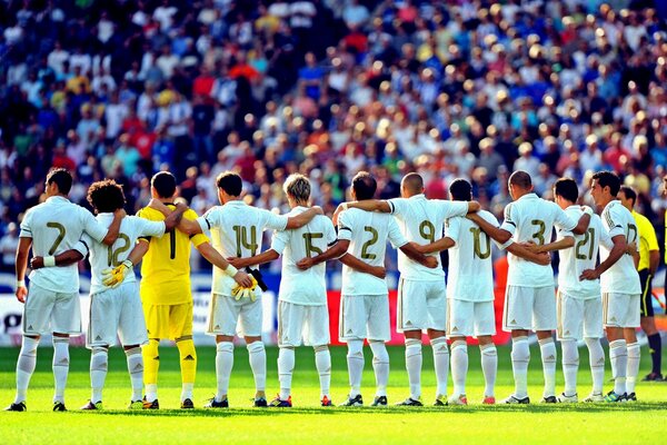 Real Madrid team listens to the anthem before a football match