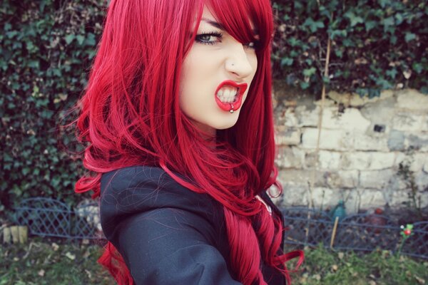 Portrait of an Aggressive girl with piercings and red hair