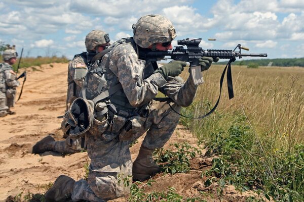 Three soldiers with weapons in the field
