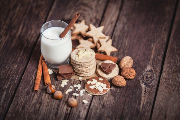 A glass of milk with cookies and nuts
