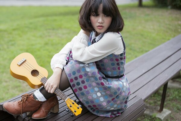 Asian girl with a guitar in her hands