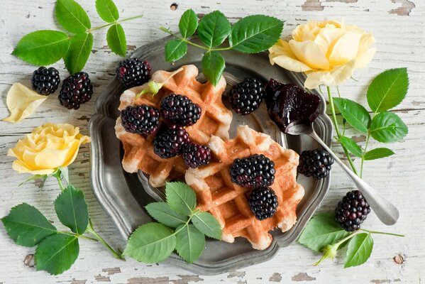 Waffles with blackberries among roses