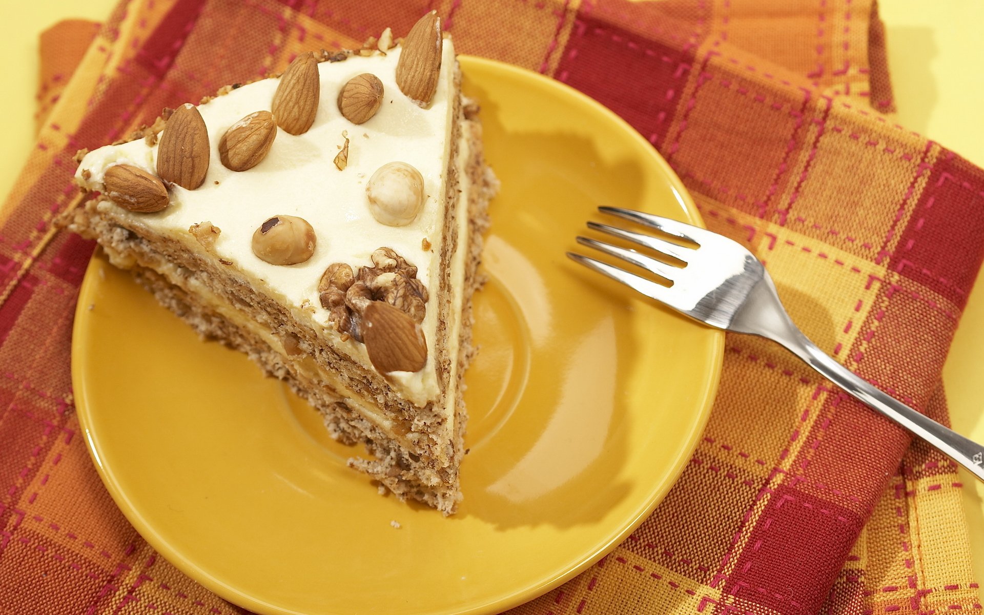 food sweet cake cake piece of cake cream chocolate nuts plate fork napkin orange background yellow background
