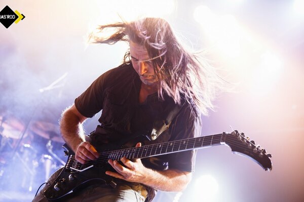 The musician enthusiastically plays the guitar