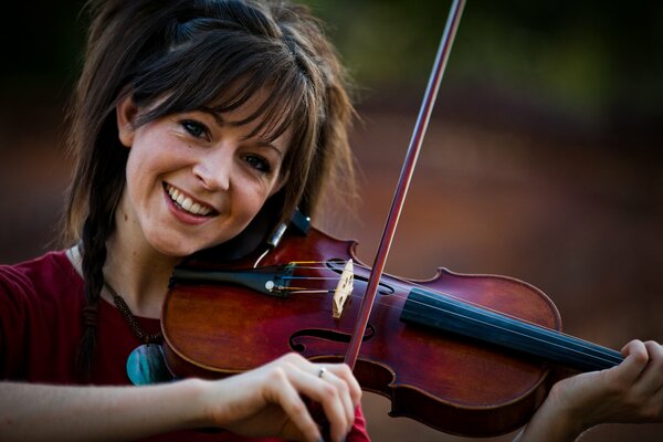 The girl plays the violin and smiles
