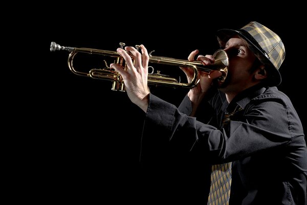 A man in a hat is fooling around with a pipe