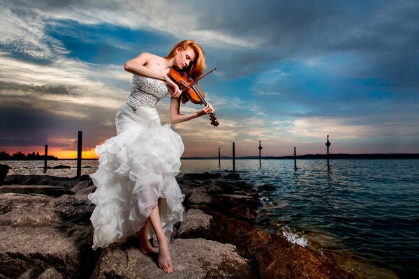 A girl in a white dress plays the violin