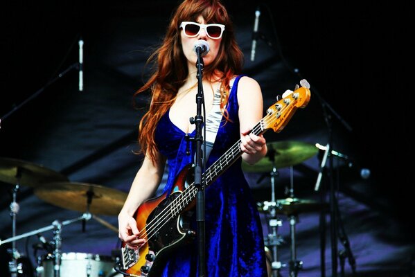Famous girl singer Jenny Lewis standing on stage and playing guitar