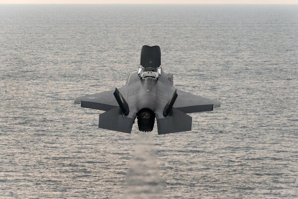 Fighter bomber takes off over the sea