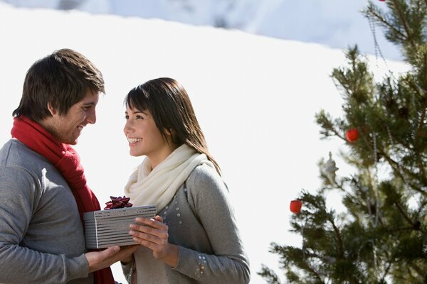 Happy guy and girl give each other gifts