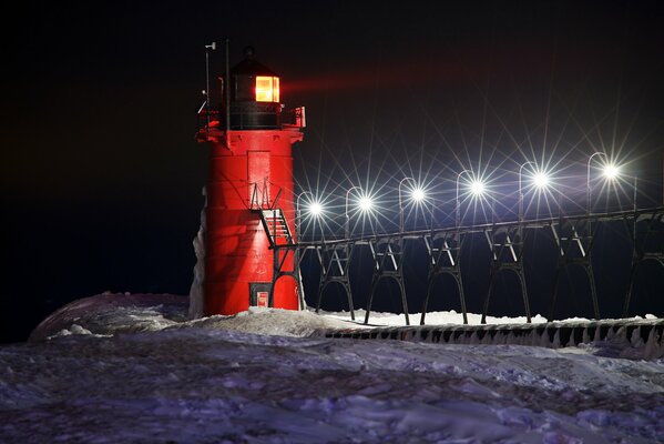 A night lighthouse among the snow in winter