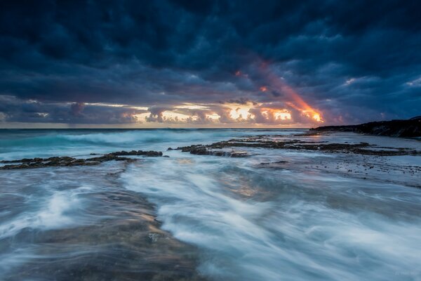 Sunset in the clouds on the background of the ocean