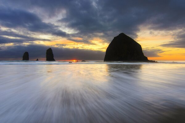 Sunset on the beach in the USA. Rocks in Oregon