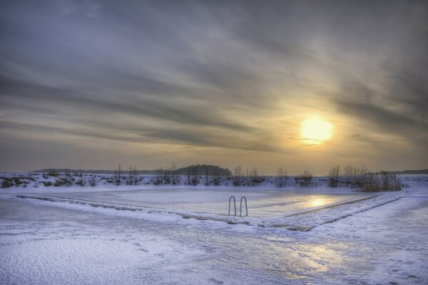 Frozen outdoor pool covered with snow