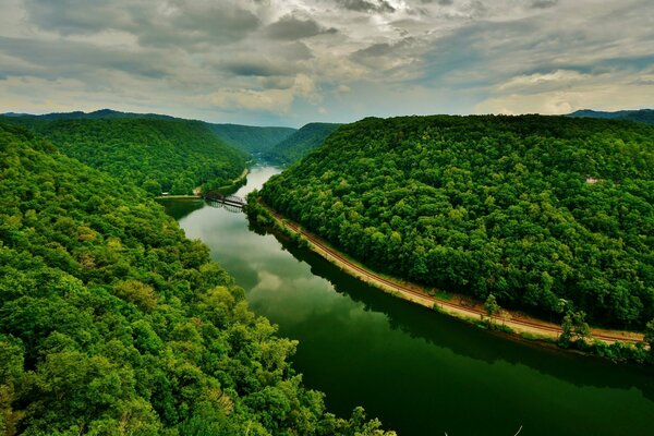 A wide river flows through the forest